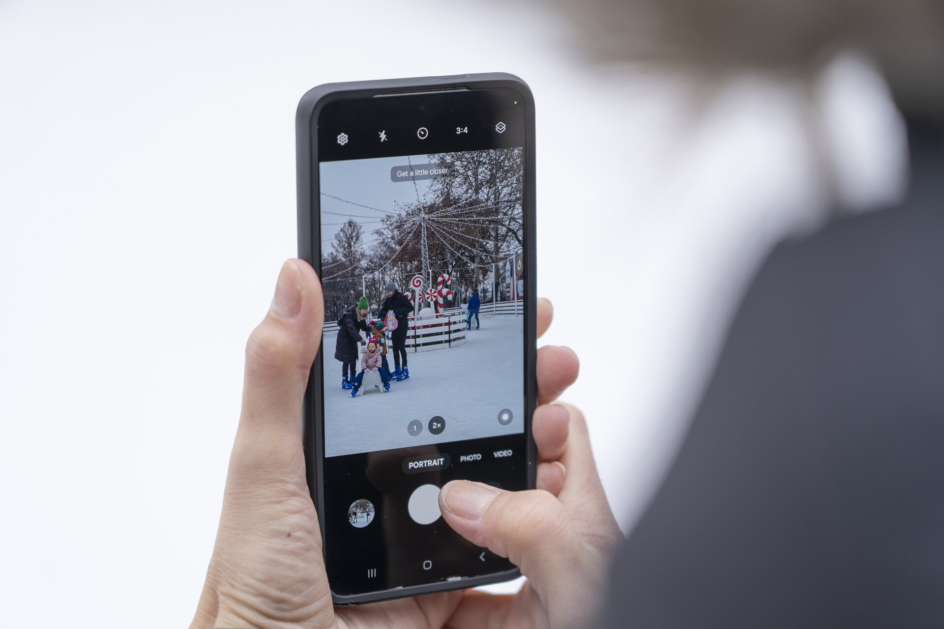 Osoba mobitelom fotografira klizače na klizalištu